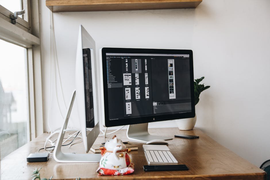 Contemporary office setup featuring dual monitors, a keyboard, mouse, and decor elements on a wooden desk.