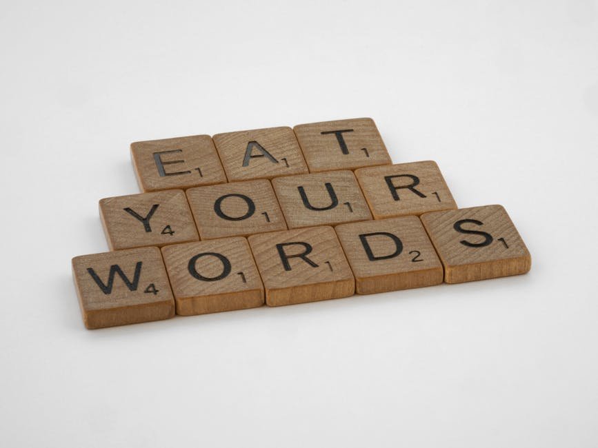 Wooden Scrabble tiles arranged to spell 'Eat Your Words' on a white background.