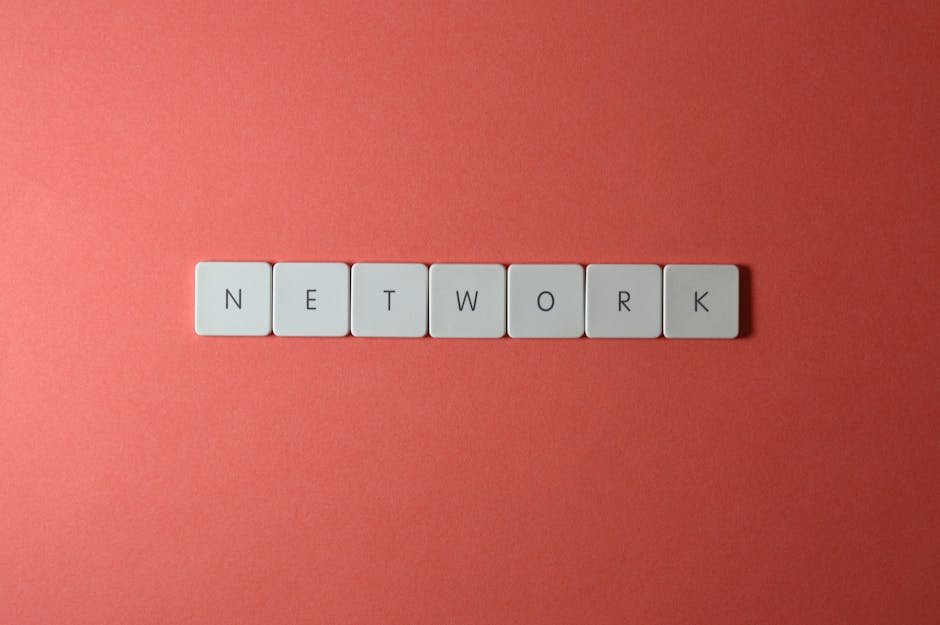 White keyboard tiles spelling 'NETWORK' on a vibrant red surface, minimalist design.